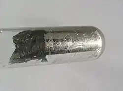 Indium (couleur métallique) au fond d'un tube à essai