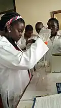 Laborantine utilisant une pipette.