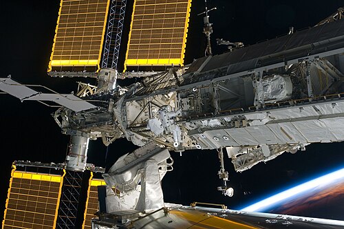 Aperçu de deux des panneaux solaires doubles. L'astronaute Steve Bowen, de la mission STS-126, qui travaille sur la poutre, donne l'échelle.
