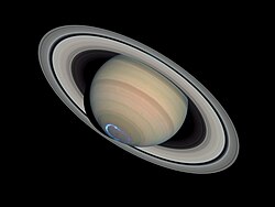 Vue éloignée de Saturne. Un cercle bleu est visible au pôle sud.