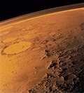 Vue de cratères et de formations montagneuses avec en haut de l'image une fiche couche visible au-dessus du sol.