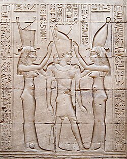 Le roi lagide Ptolémée VIII en tenue de pharaon, entre les déesses Ouadjet et Nekhbet. Temple d'Horus à Edfou.