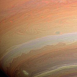 Gros plan sur la planète. on observe des nuances d'orange et de blanc en bandes.