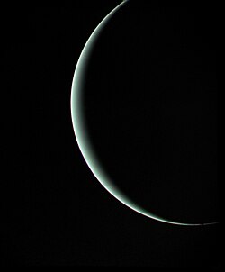 Uranus apparaissant comme un fin croissant lumineux devant un fond noir.