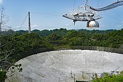 Photographie en couleurs, en plongée, du radiotélescope d'Arecibo.
