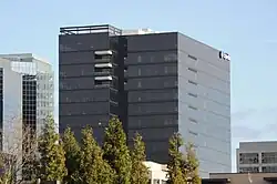 Un bâtiment moderne, sombre, avec une façade en verre