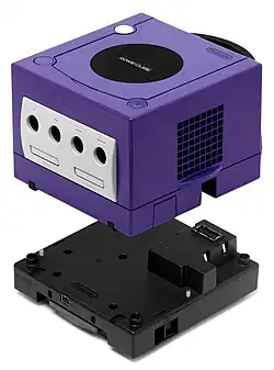 Photo représentant une Game Boy Player se trouvant sous une Nintendo GameCube prés à être fixé.