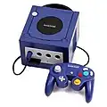 Photo représentant une Nintendo GameCube de couleur Spice (orange) et de deux manettes.