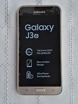 un téléphone couleur doré, avec écran allumé