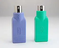 Convertisseurs USB → PS/2 pour clavier (bleu-violet) et souris (vert).