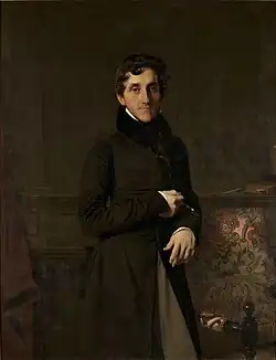 Portrait d'un fonctionnaire du Premier Empire : vêtu d'une redingote noire, celui-ci est debout, accoudé au dossier d'un fauteuil, le regard détaché, l'air serein.