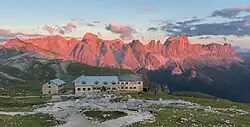 L'alpenglow sur le groupe du Catinaccio (ici au moment du coucher du soleil), avec le refuge Bolzano au premier plan.